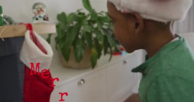 Afro-Amerikan çocuğun Noel Baba şapkası takması üzerine Mutlu Noeller mesajı. Noel, gelenek ve kutlama konsepti dijital olarak oluşturuldu.