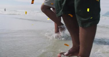 Sahildeki üst düzey melez çiftin üzerine düşen noel konfetisinin animasyonu. Noel, gelenek, kutlama ve şenlik kavramı dijital olarak oluşturuldu.