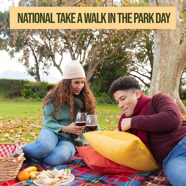 Composition ofnational take a walk in the park day text and couple in park. National take a walk in the park day and nature concept digitally generated image.