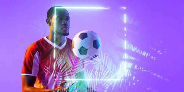 非裔美国男性足球运动员 球站在灯火通明的正方形和植物旁边 复制空间 霓虹灯 烟雾和抽象 — 图库照片