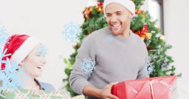 Noel 'de Noel Baba şapkalı beyaz bir adam üzerinde hediyelerle Noel kar tanelerinin canlandırılması. Noel, şenlik, kutlama ve gelenek konsepti dijital olarak oluşturuldu.