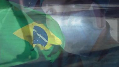 Yüz maskeli beyaz doktorların üzerinde Brezilya bayrağı animajı. Küresel vatanseverlik, salgın hastalık ve dijital arayüz kavramı dijital olarak oluşturulmuş video.