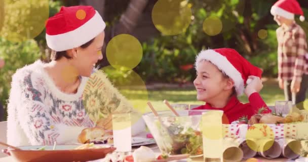 Animación Manchas Amarillas Sobre Familia Caucásica Sombreros Santa Mesa Navidad — Vídeos de Stock