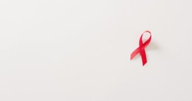 Kırmızı HIV videosu ya da beyaz arkaplanda kopyalama alanı olan farkındalık kurdelesi. Sağlık hizmetleri, sağlık hizmetleri ve sağlık farkındalığı kavramı.