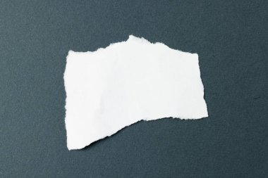 Siyah arkaplanda kopyalama alanı olan yırtılmış beyaz kağıt parçası. Soyut kağıt dokusu arka plan ve iletişim konsepti.