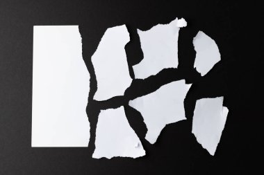 Siyah arka planda kopyalama alanı olan yırtık beyaz kağıt parçaları. Soyut kağıt dokusu arka plan ve iletişim konsepti.