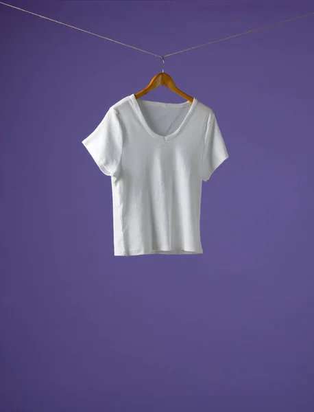 Koszulka Wisząca Wieszaku Miejsce Fioletowym Tle Odzież Moda Koncepcja Sprzedaży — Zdjęcie stockowe