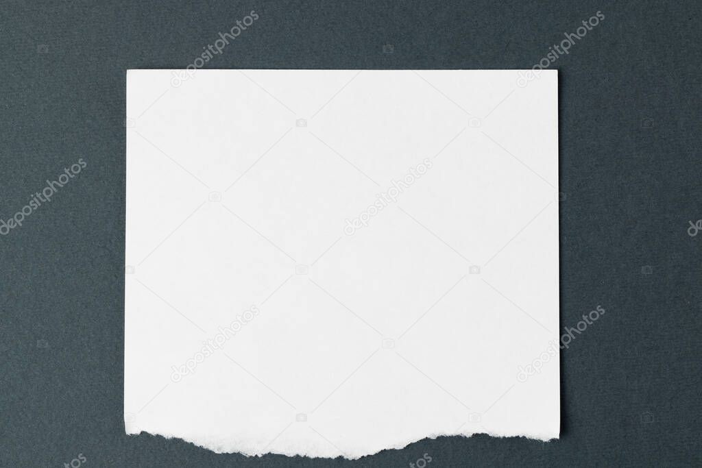 Ripped up piece of white paper with copy space on black background. Abstract paper texture background and communication concept.
