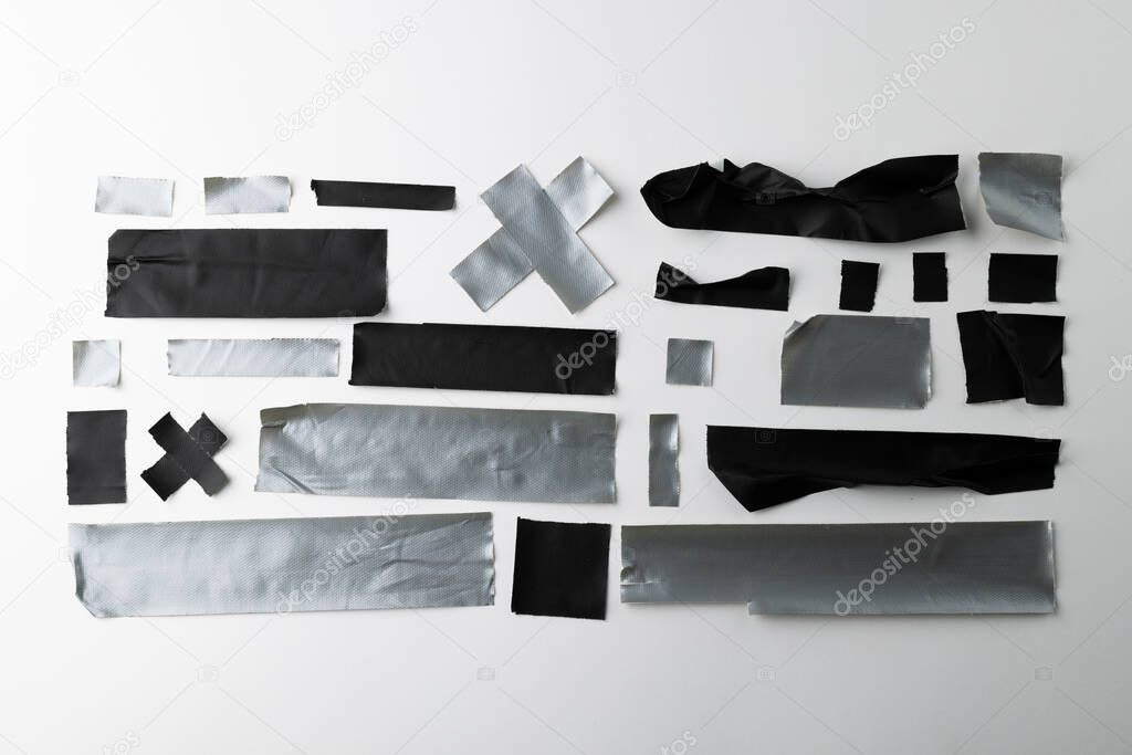 Ripped up pieces of black and silver tape on white background. Abstract paper texture background and communication concept.