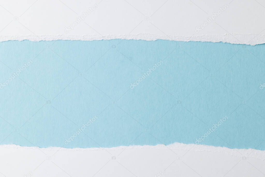 Ripped up pieces of white paper with copy space on blue background. Abstract paper texture background and communication concept.
