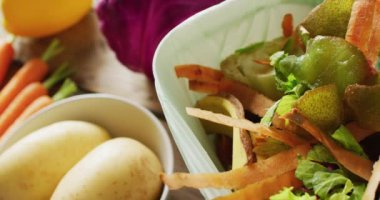 Mutfak gübreleme kutusundaki organik ve sebze atıklarının videosunu kapatın, arkasında sebzeler olsun. Ekoloji, geri dönüşüm, bakım ve doğa konsepti.