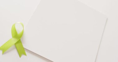 Soluk yeşil STD farkındalık şeridi ve beyaz arka planda fotokopi alanı olan beyaz kart videosu. Sağlık hizmetleri, sağlık hizmetleri ve sağlık farkındalığı kavramı.