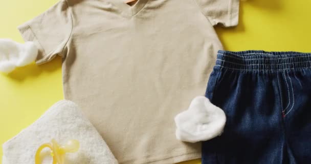 黄色の背景にシャツ デニムスカート ダミーで赤ちゃんの女の子の衣装のクローズアップのビデオ 赤ちゃん ファッション ファブリック テクスチャと材料の概念 — ストック動画