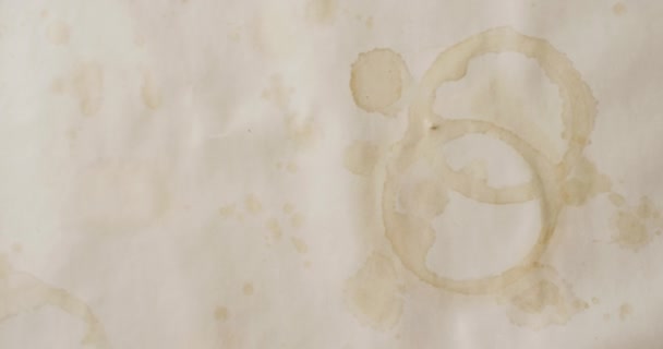 在白色背景上贴有圆形咖啡杯污迹的纸片的特写视频 纹理和材料概念 — 图库视频影像