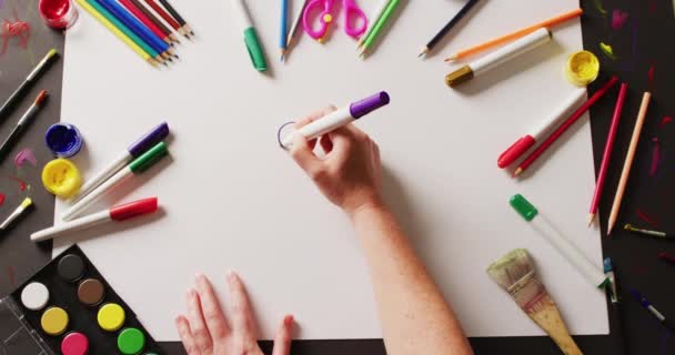 紙に紫色のペンで手描きのビデオ テーブルの上に配置された様々なアート材料と 創造性 工芸品 趣味の概念 — ストック動画