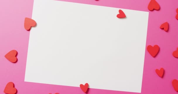 ピンクの背景に コピースペースのある紙の赤い紙のハート型と黒の白いシートのビデオ バレンタインデー ロマンス 愛とお祝いのコンセプト — ストック動画