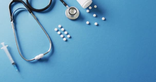 Filmik Stetoskopu Strzykawką Białymi Tabletkami Niebieskim Tle Przestrzenią Kopiowania Medycyna — Wideo stockowe