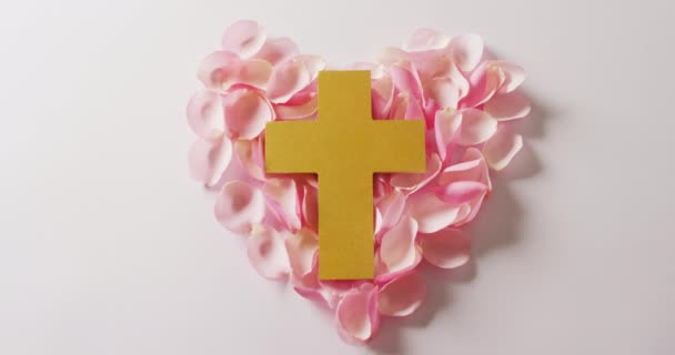 Video Cruz Cristiana Amarilla Forma Corazón Pétalos Rosa Sobre Fondo — Vídeos de Stock