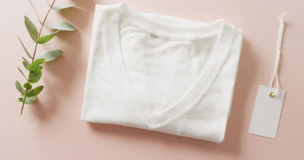 Wideo Bliska Białym Składanym Shirt Tagiem Różowym Tle Koncepcja Odzieży — Wideo stockowe
