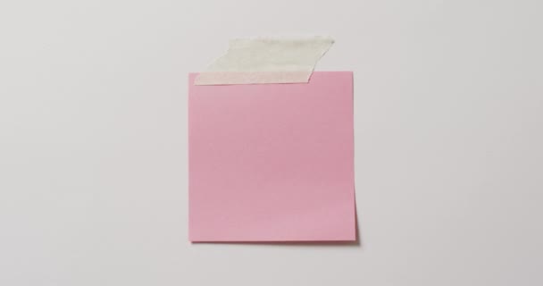 Video Der Nahaufnahme Einer Rosafarbenen Notiz Mit Kopierraum Auf Weißem — Stockvideo