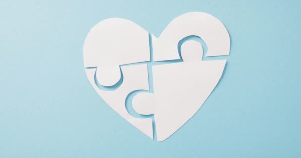 コピースペースと青の背景に白いジグソーパズルの心のビデオ 医療サービス 医療と健康意識の概念 — ストック動画