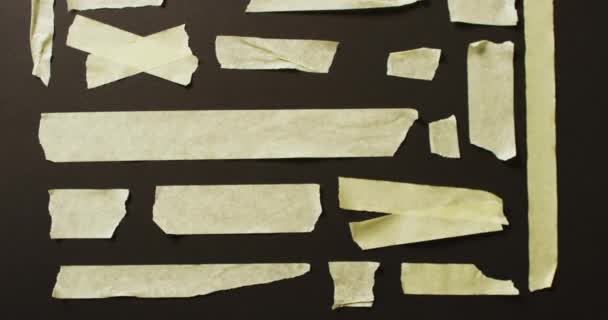 Videó Közeli Több Sárga Papír Szalagok Darab Fekete Alapon Papír — Stock videók