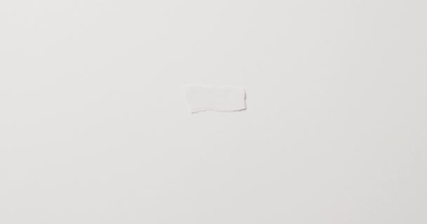 白い背景にコピースペースを持つ紙の引き裂かれた部分のクローズアップのビデオ 素材のコンセプト — ストック動画