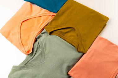 Renkli tişörtleri kapatın ve beyaz arkaplanda kopya alanı oluşturun. Giyim, moda ve perakende konsepti.