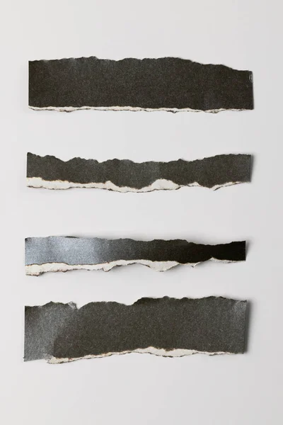 Beyaz Arka Planda Kopyalama Alanı Olan Yırtık Siyah Kağıt Parçaları — Stok fotoğraf