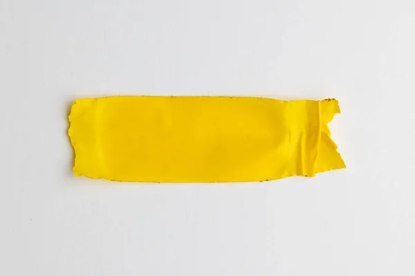stock image Ripped up piece of yellow tape with copy space on white background. Abstract paper texture background and communication concept.
