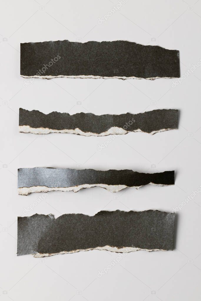 Ripped up pieces of black paper with copy space on white background. Abstract paper texture background and communication concept.