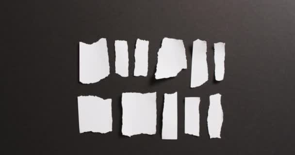 黒い背景に白い紙の複数の引き裂かれた部分のクローズアップのビデオ 素材のコンセプト — ストック動画