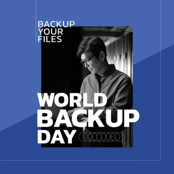 Composition of world backup day text over asian man using laptop. World backup day and celebration concept digitally generated image.