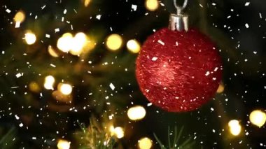 Yılbaşı süslerinin üzerine yağan kar ve siyah arka planda hafif lekeler. Noel, gelenek ve kutlama konsepti dijital olarak oluşturuldu.