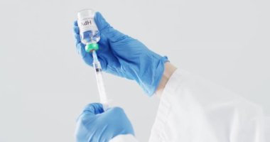 Doktorun eldiven giyip şırıngayı HPV aşısıyla doldurduğu görüntüler. Gri kopya alanı var. Tıp, sağlık hizmetleri, sağlık hizmetleri ve sağlık farkındalığı kavramı.