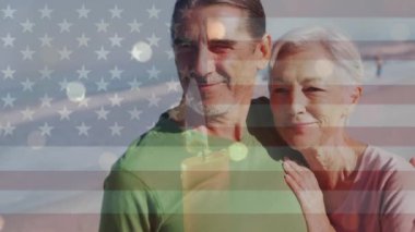 Amerika Birleşik Devletleri bayrağının sahildeki Kafkasyalı yaşlı çift üzerinde canlandırılması. Amerikan vatanseverliği ve demokrasi konsepti dijital olarak oluşturulmuş video.