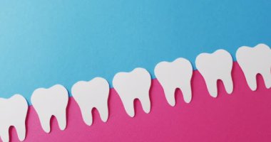 Mavi arka planda pembe sakızlı beyaz dişlerin fotokopi çekilen videosu. Sağlık hizmetleri, sağlık hizmetleri ve diş sağlığı farkındalığı kavramı.