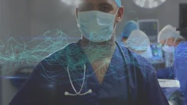 Hastanede cerrahi maske takmış melez erkek cerrahın portresinin üzerindeki mavi dijital dalgaların animasyonu. Tıbbi sağlık ve teknoloji konsepti