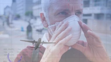 Yüz maskesi takan beyaz adamın üzerinde veri işleme ve uçak animasyonu. Dijital olarak oluşturulmuş küresel salgın, bilgisayar ve dijital arayüz kavramı.