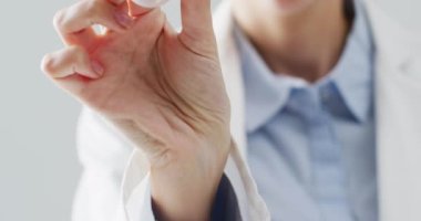 Kafkasyalı kadın doktorun işitme cihazını tuttuğu video, seçici odaklanma. Tıp, duyular, işitme, sağlık, sağırlık ve sağlık farkındalığı kavramı.