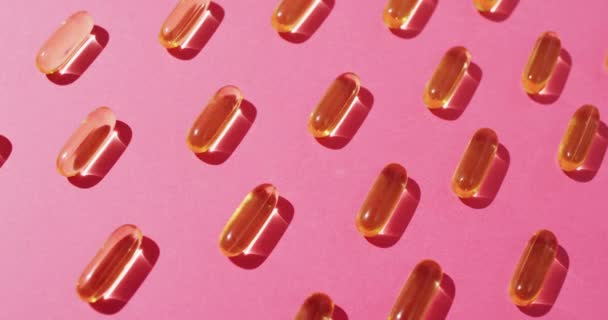 Video Oil Capsules Arranged Rows Pink Background Medicine Medical Services — Stock Video