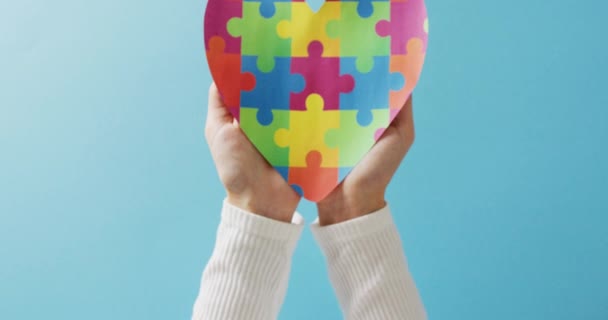 Video Hands Holding Jigsaw Puzzle Heart Blue Background Copy Space — Stock Video