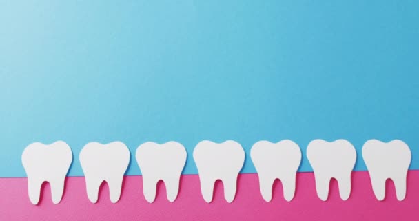 Wideo Białymi Papierowymi Zębami Różowej Gumie Niebieskim Tle Przestrzenią Kopiowania — Wideo stockowe
