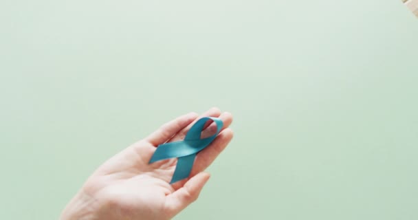 Video Der Hand Mit Blauem Eierstockkrebs Bewusstseinsband Auf Grünem Hintergrund — Stockvideo