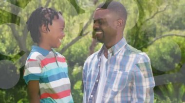 Afro-Amerikan baba animasyonu. Oğlu şekil değiştirerek parkta gülümsüyor. Aile, aşk ve dijital arayüz kavramı dijital olarak oluşturulmuş video.