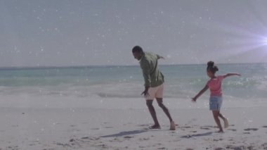 Afrika kökenli Amerikalı bir adam ve kızının kumsaldaki ışık izlerinin canlandırması. Yaşam tarzı, aile ve tatiller dijital olarak oluşturulmuş video konsepti.