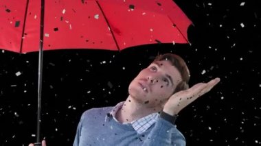 Siyah arka planda şemsiyesi olan beyaz bir adamın üzerine düşen konfeti animasyonu. Parti ve kutlama konsepti dijital olarak oluşturuldu.