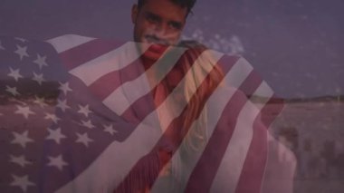 Amerika Birleşik Devletleri bayrağının plajdaki beyaz çift üzerinde canlandırılması. Amerikan vatanseverliği ve demokrasi konsepti dijital olarak oluşturulmuş video.