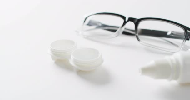 Video Glasögon Kontaktlinser Fall Och Linslösning Vit Bakgrund Med Kopieringsutrymme — Stockvideo