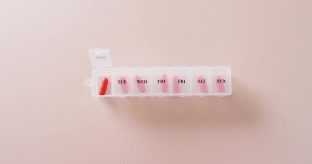 Videó Piros Tabletták Heti Tabletta Doboz Rózsaszín Háttér Másolási Hely — Stock videók